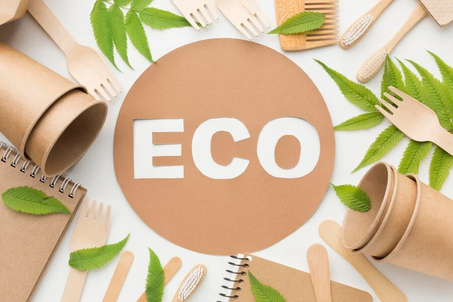 a paper plate with the word eco surrounded by leaves and forks